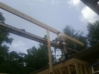 Carpenter setting a ridge beam over a new addition frame — Ice Dam Removal by Roofing Brothers in Southington
