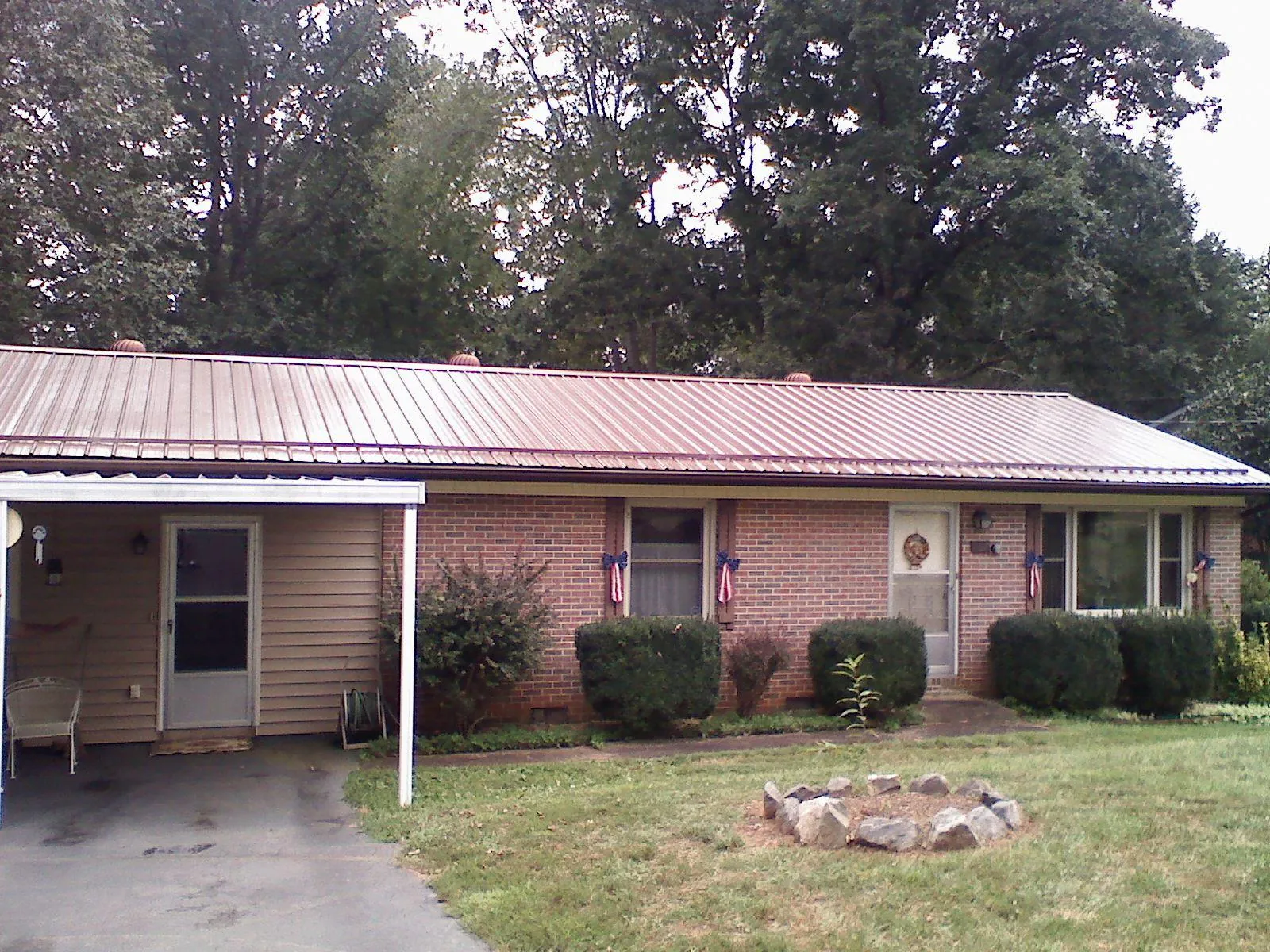 Bronze metal roof and carport on a brick ranch home — Roof Repair work by our crew in Southington